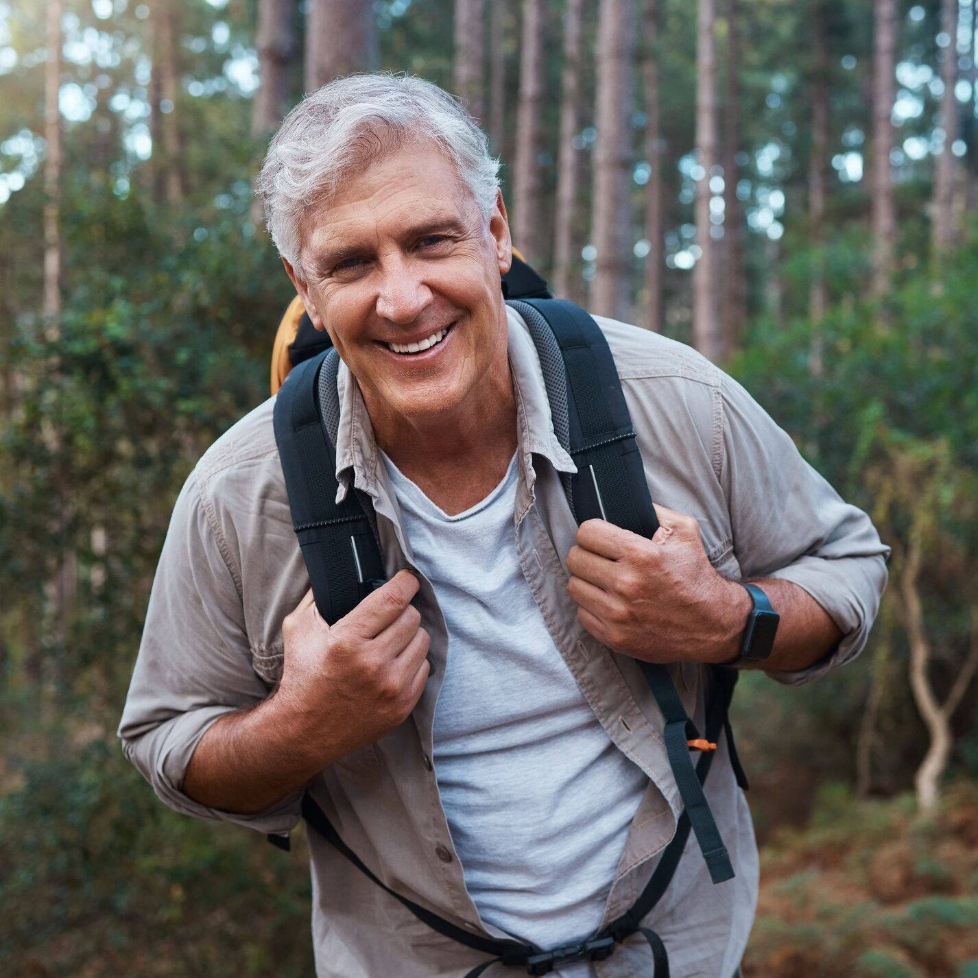 Shot of a mature man wearing his backpack while out hiking